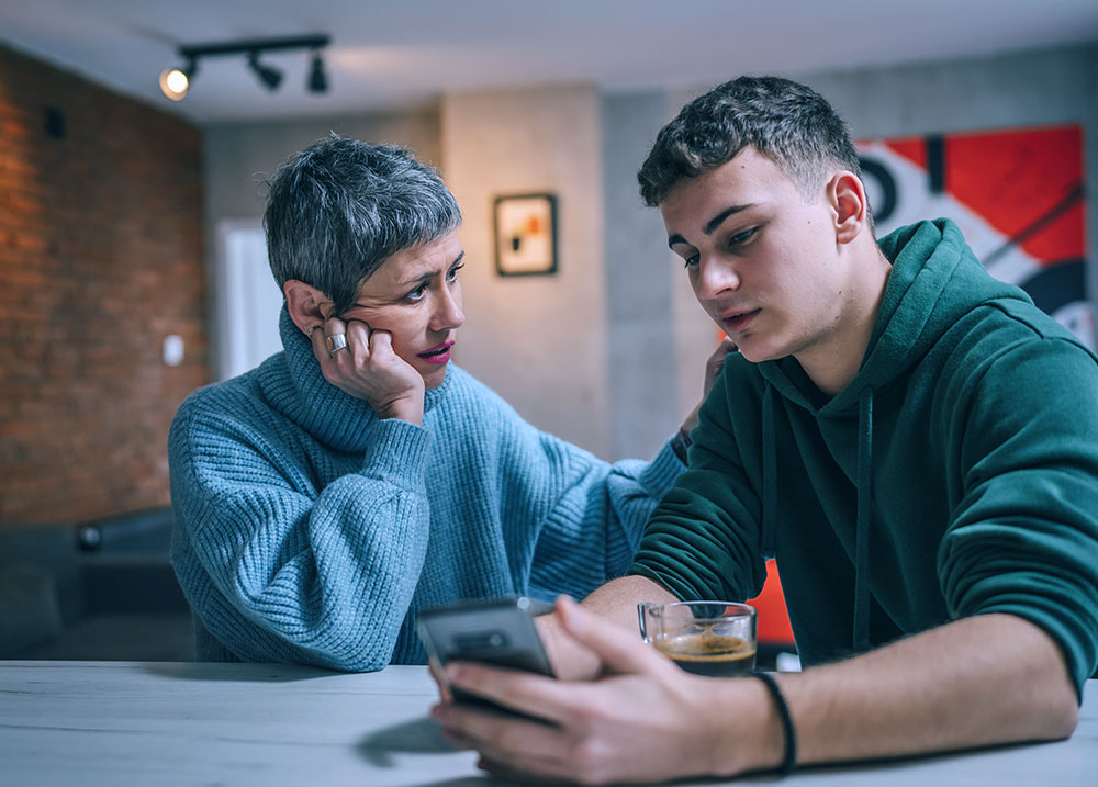 mom comforting her son at the kitchen table