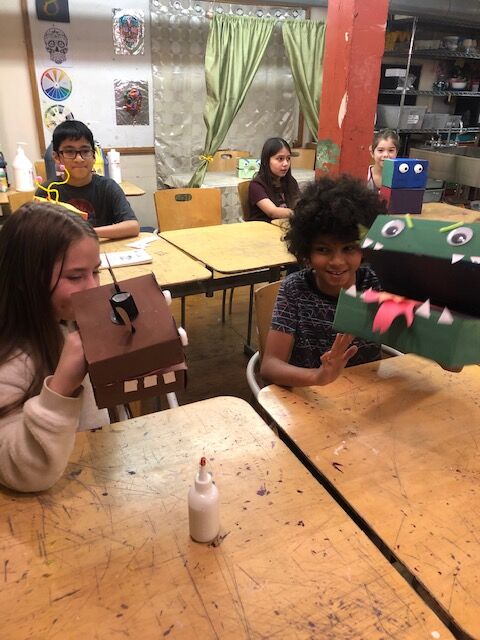 girl and boy holding puppets