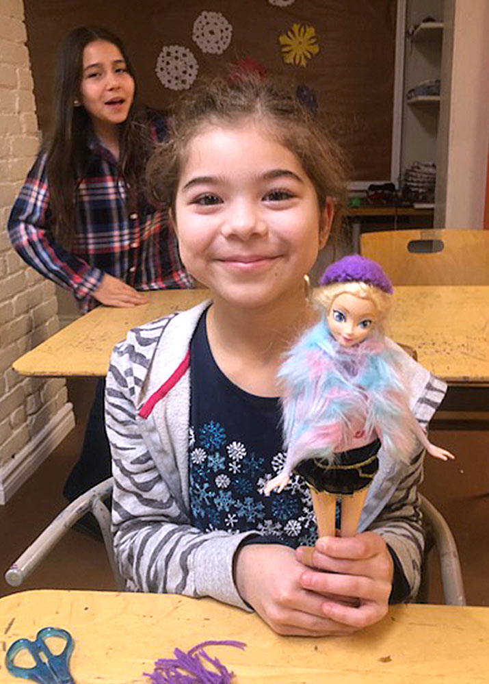 girling playing with barbie doll