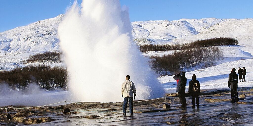 people watching a geyser